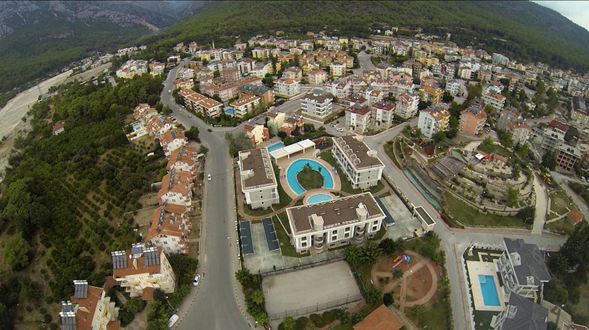 Новый жилой комплекс в живописной долине среди хвойного леса с видом на горы