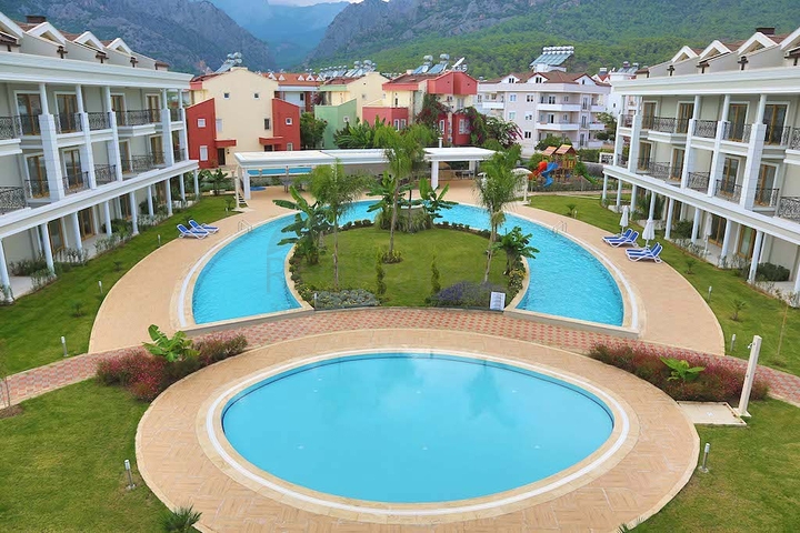 Новый жилой комплекс в живописной долине среди хвойного леса с видом на горы