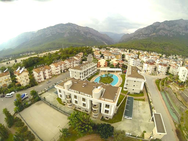 Новый жилой комплекс в живописной долине среди хвойного леса с видом на горы