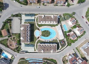 Новый жилой комплекс в живописной долине среди хвойного леса с видом на горы