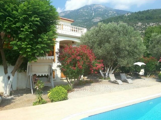 Дом в горном ущелье с зеленым садом