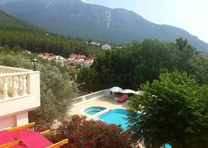 Дом в горном ущелье с зеленым садом