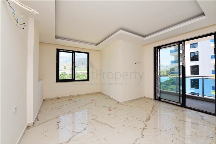 Двухкомнатная квартира с панорамным видом на горы в районе Махмутлар